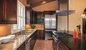 A kitchen with stainless steel appliances and granite counter tops.