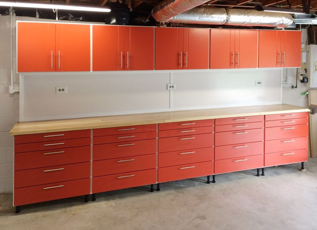 Orange cabinets and drawers with a wooden countertop in a garage.