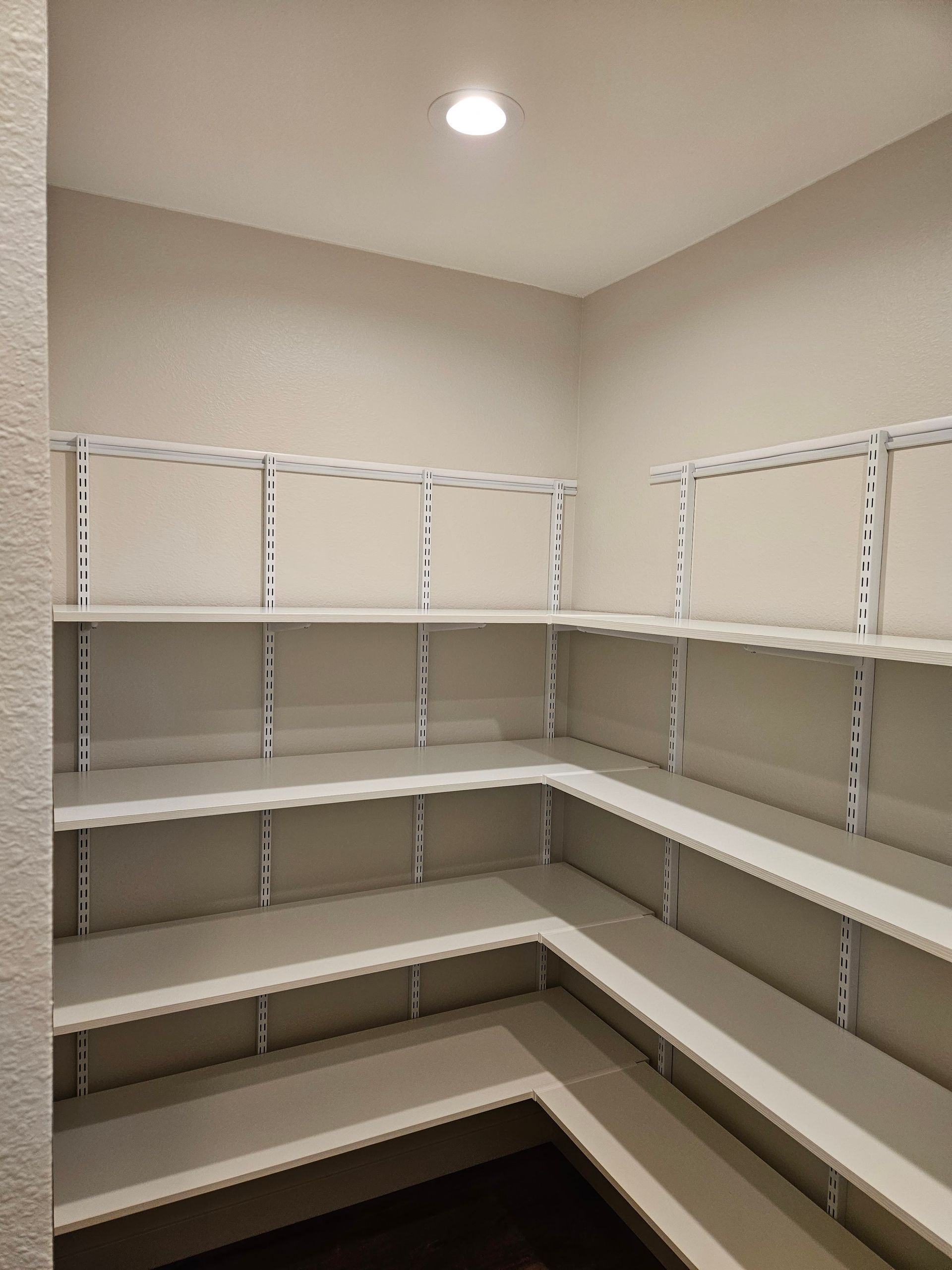 A walk in closet with lots of shelves and drawers