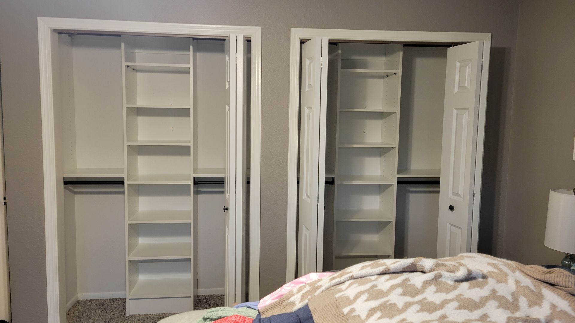 A bedroom with two closets and a bed