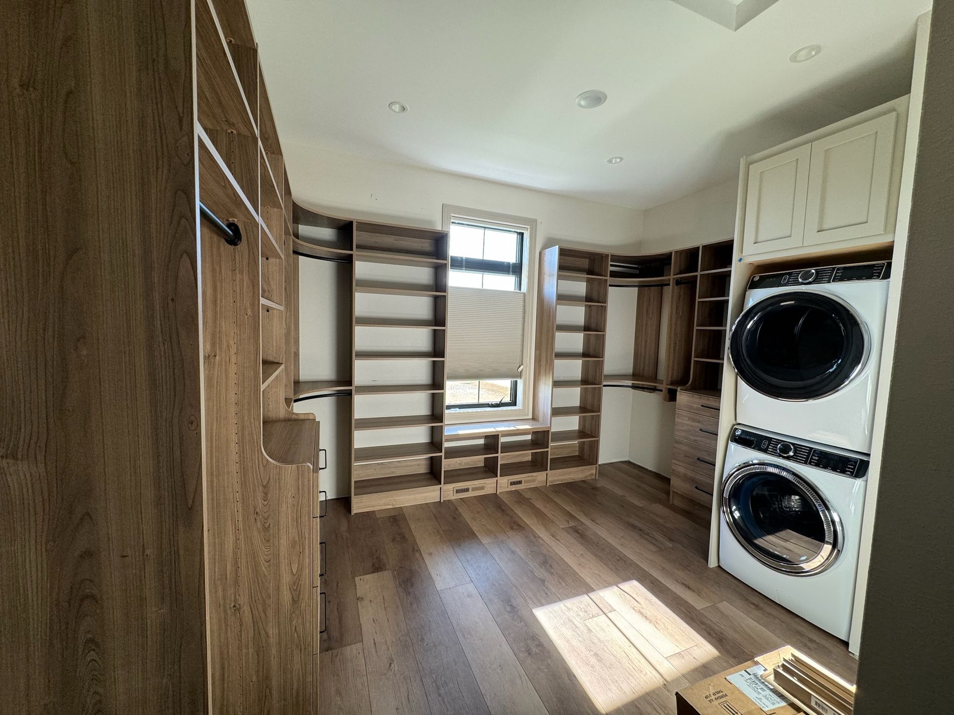 A walk in closet with a washer and dryer stacked on top of each other