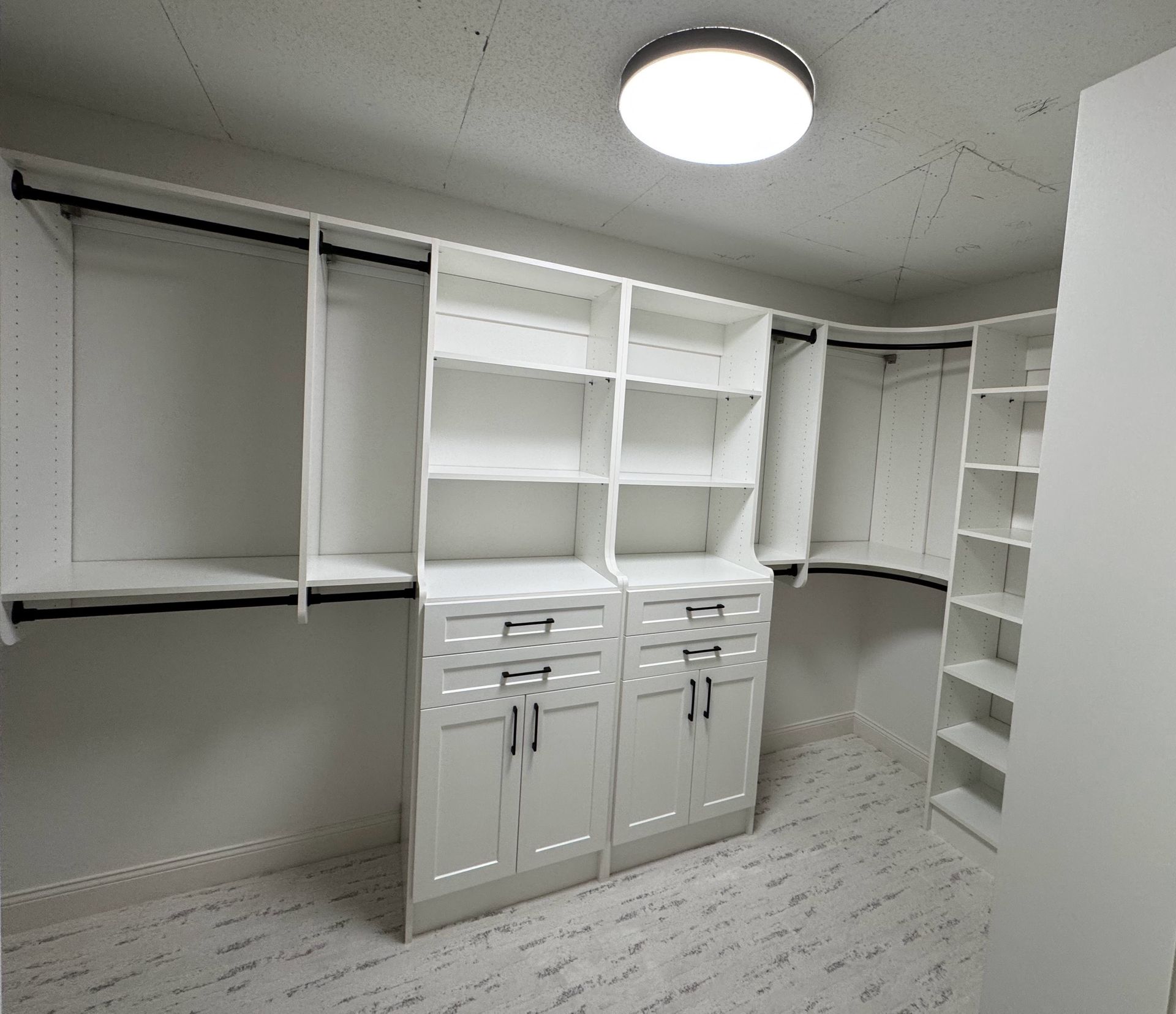 A walk in closet with lots of shelves and drawers