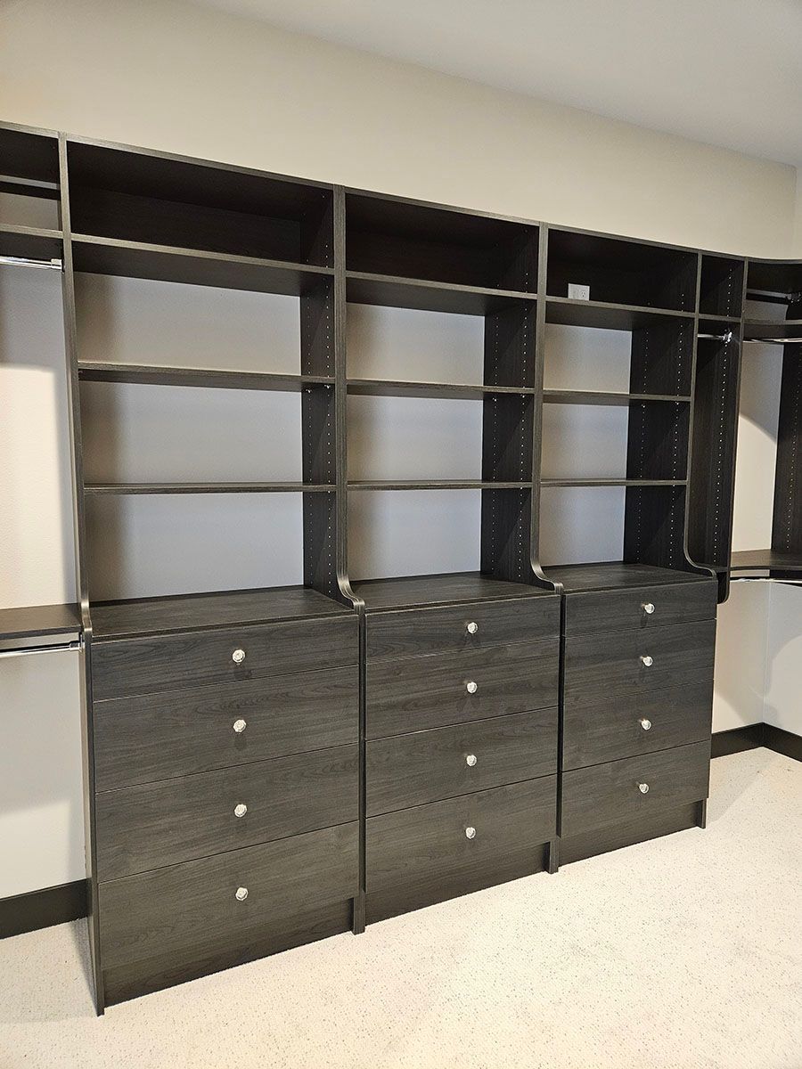 A walk-in closet with lots of shelves and drawers