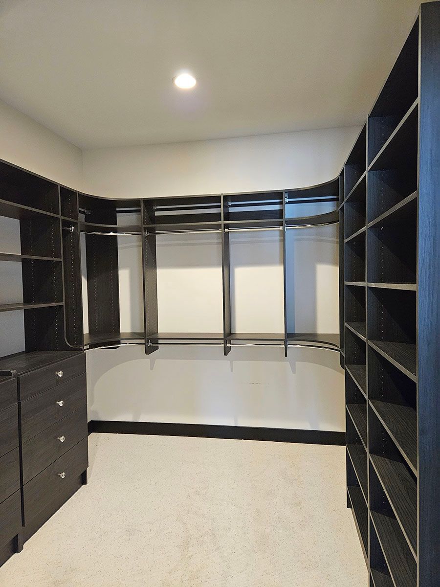 A walk-in closet with lots of shelves