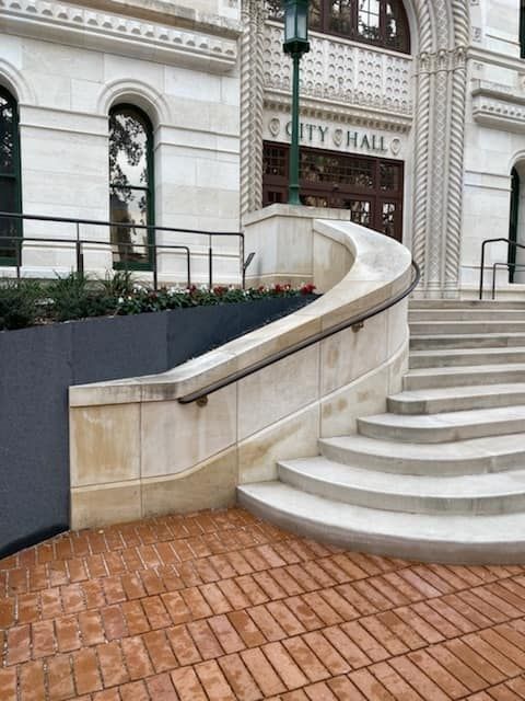 A large building with a blue roof and a red curb in front of it.