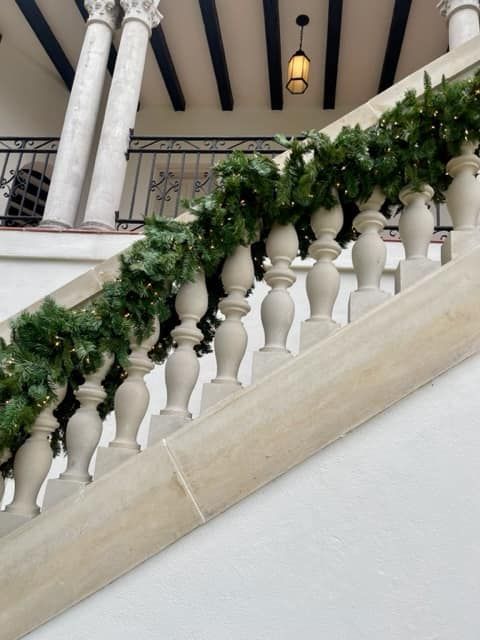 A staircase with a christmas garland on the railing