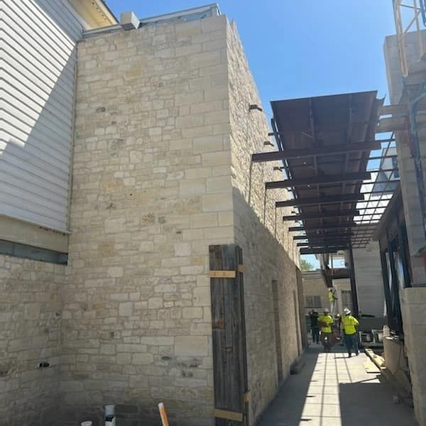 A group of construction workers are working on a brick building