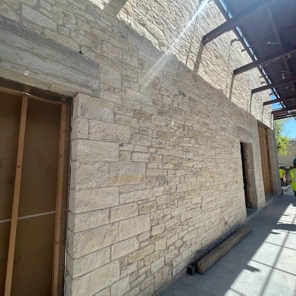 A brick wall is being built in a building under construction.