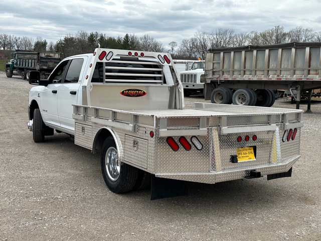 White Ram pickup truck with a flatbed, parked on gravel.