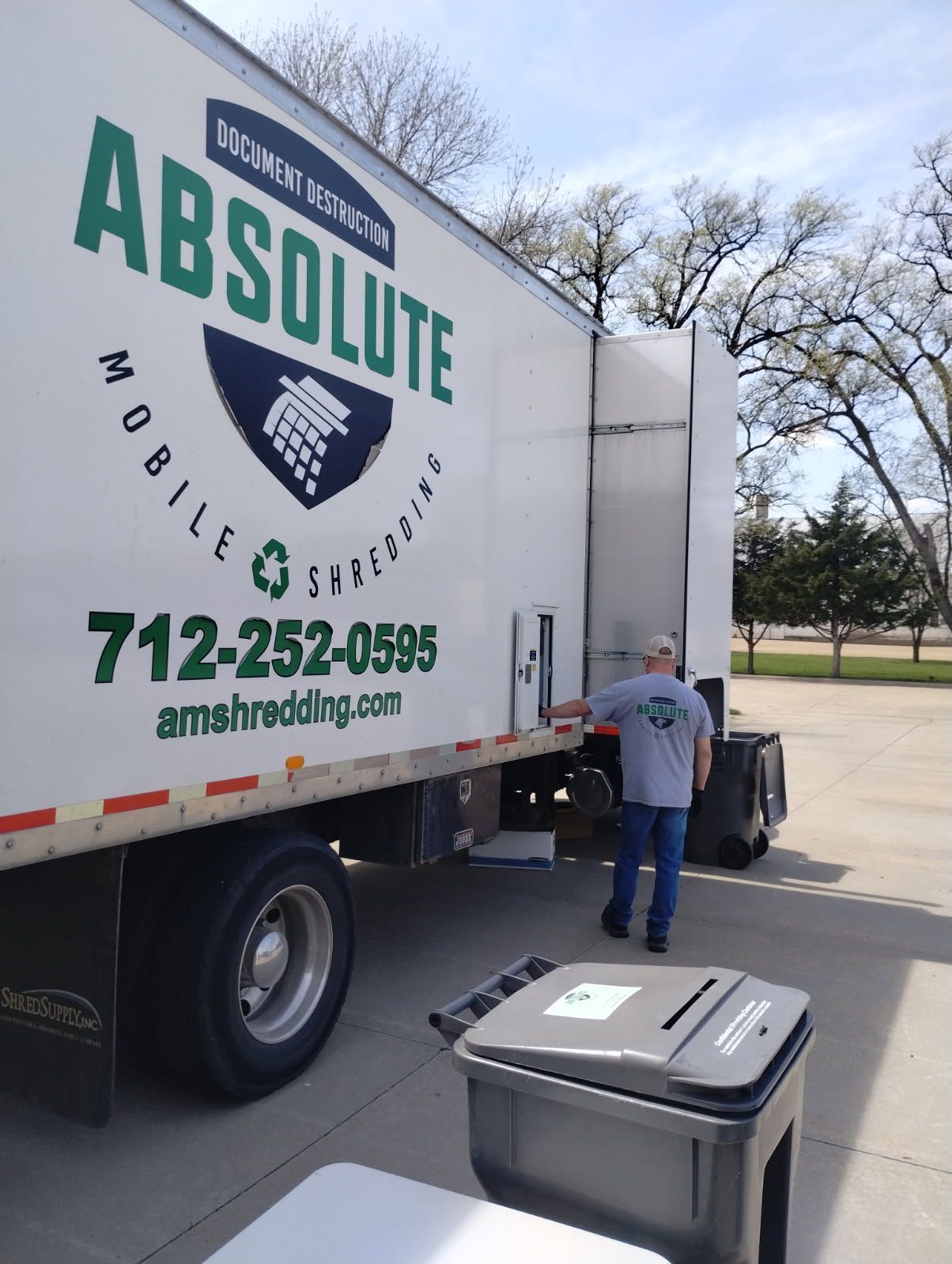 A man is standing in front of an absolute mobile storage truck