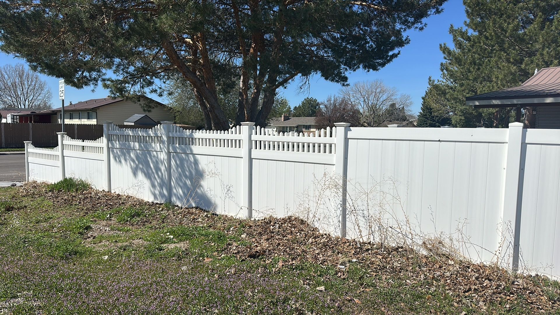 A white fence with a tree in the background