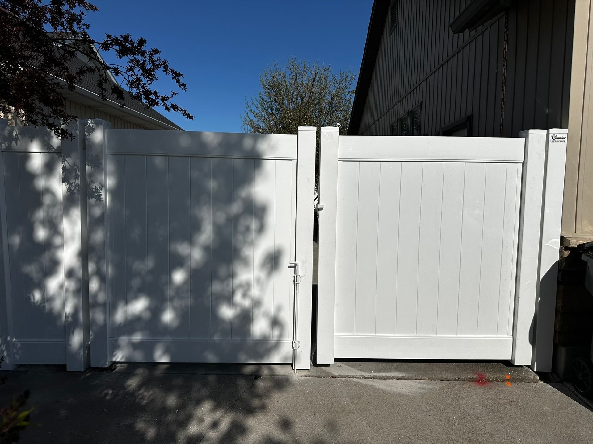 A white fence with a gate in front of a house.