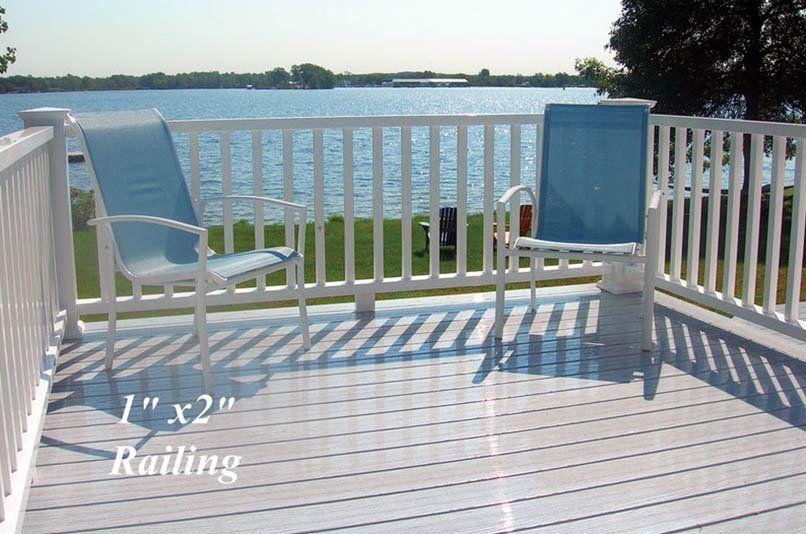 A white railing on a deck overlooking a body of water