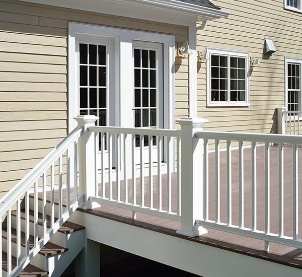 A house with a white railing and stairs leading up to it