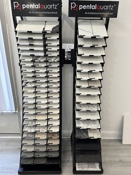 Two black floor tile display stands with various quartz samples.