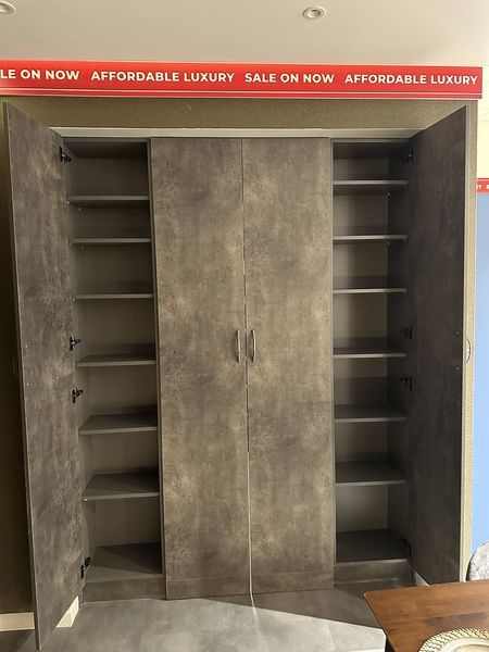 Gray wooden wardrobe with open doors displaying shelves; 