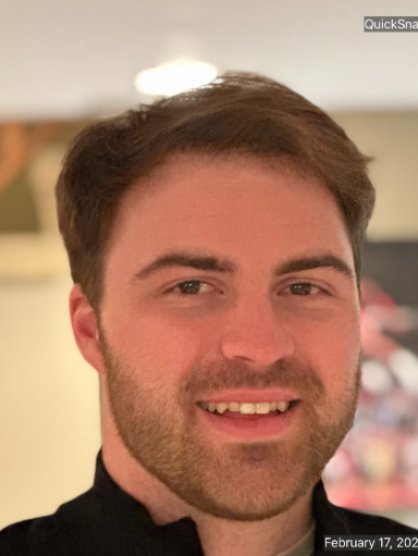 A man with a beard is smiling for the camera