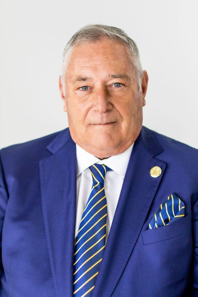 Man in blue suit, striped tie, and pocket square, looking at the viewer.