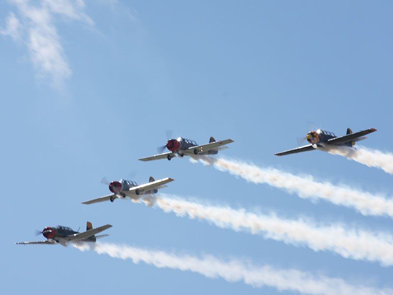 Four airplanes are flying in formation in the sky.
