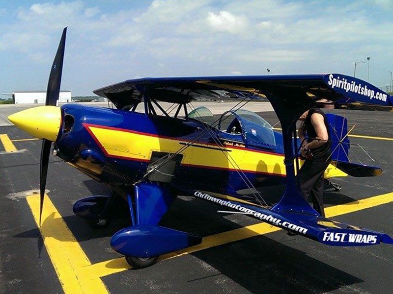 A blue and yellow airplane is parked in a parking lot