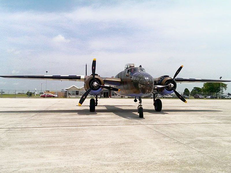 A plane is parked on a runway with the letters b-24 on the front