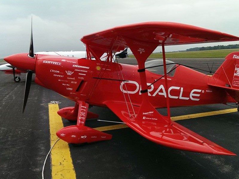A red oracle plane is parked on a runway