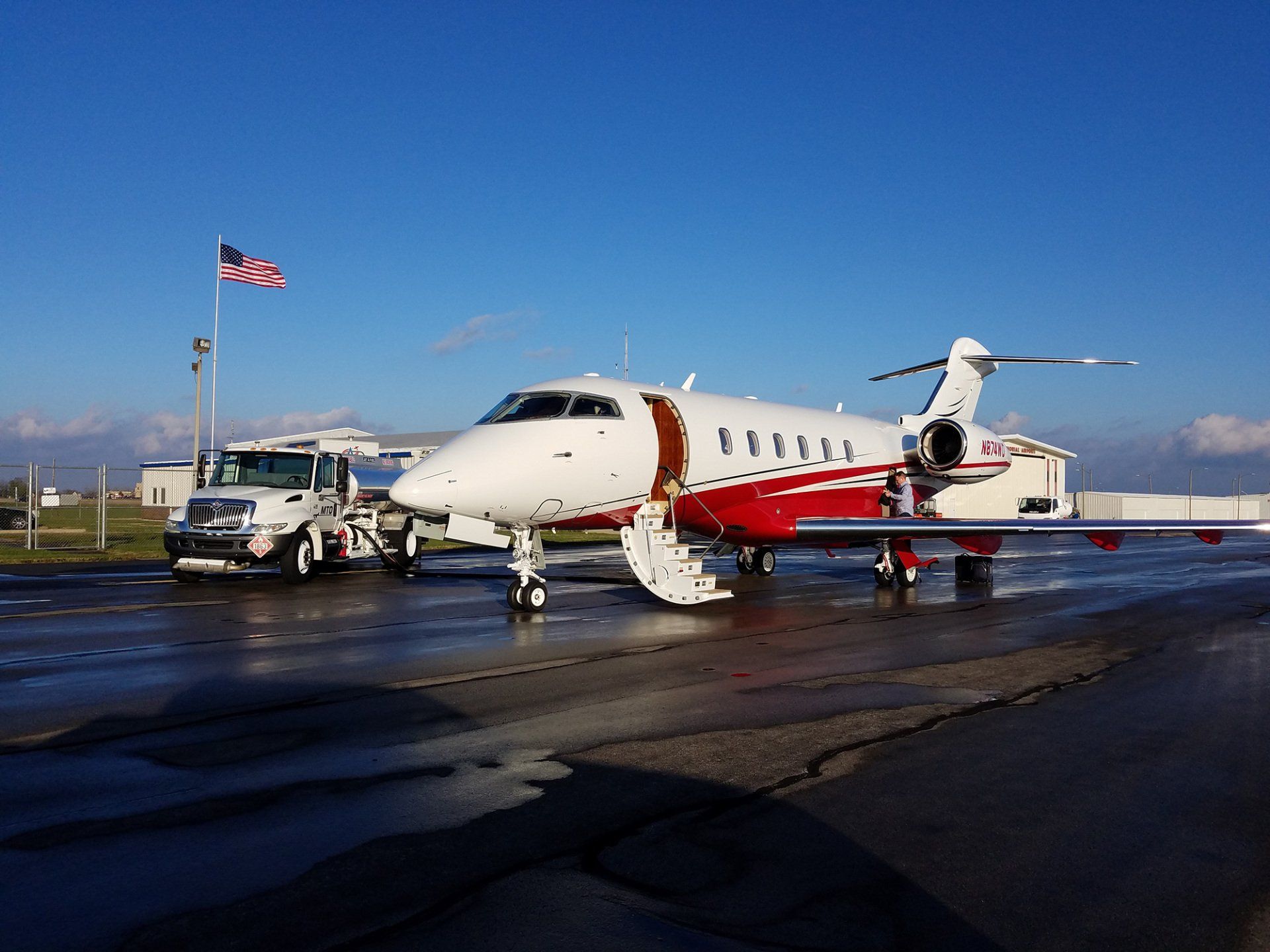 A stella airplane is parked on the runway next to a truck.