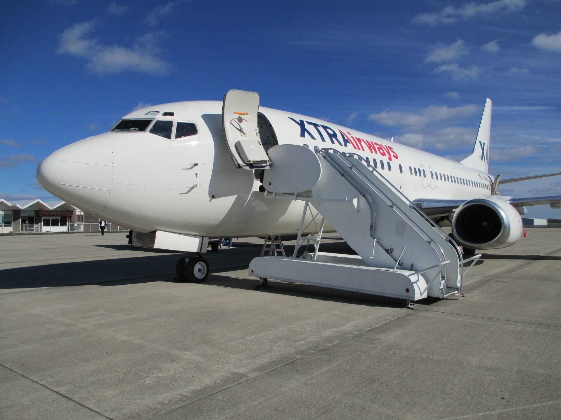 A white xtra power airplane is parked on a runway