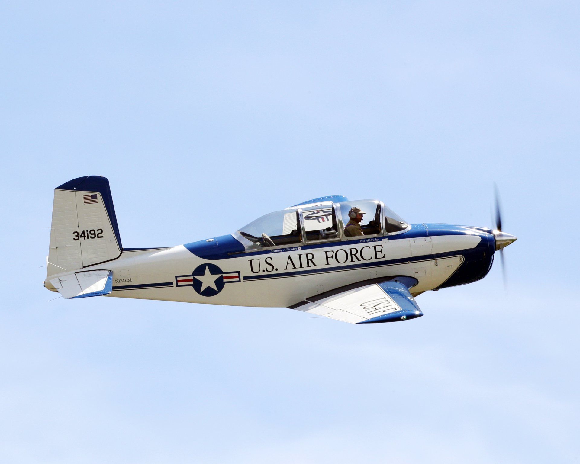 A small u.s. air force plane is flying in the sky