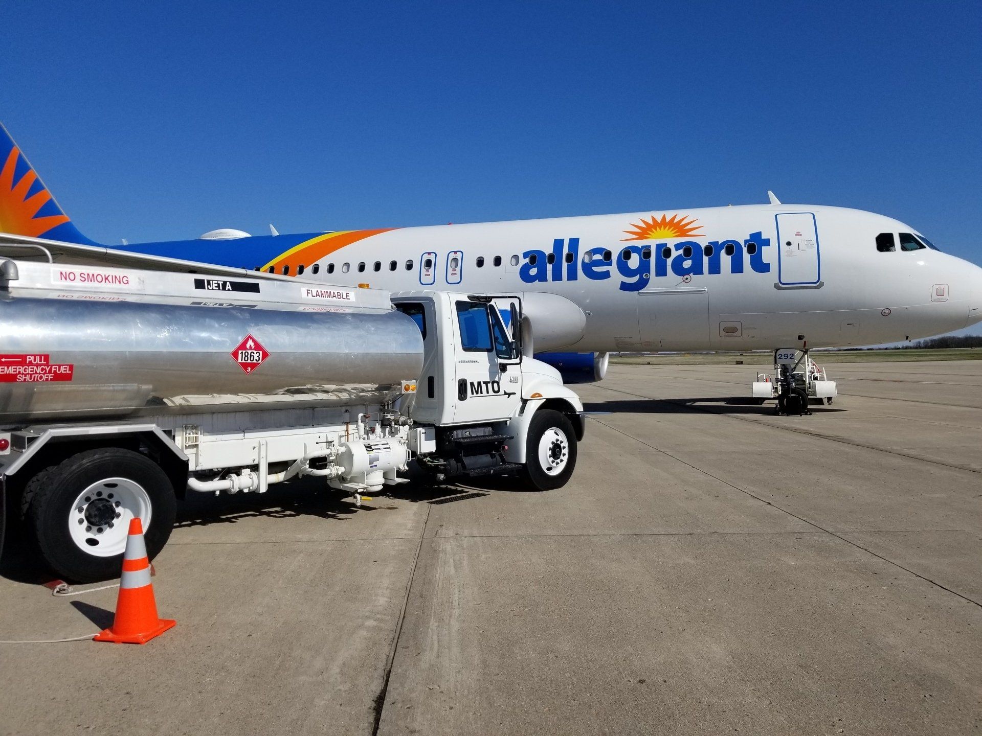 An allegiant airplane is being refuelled by a tanker truck