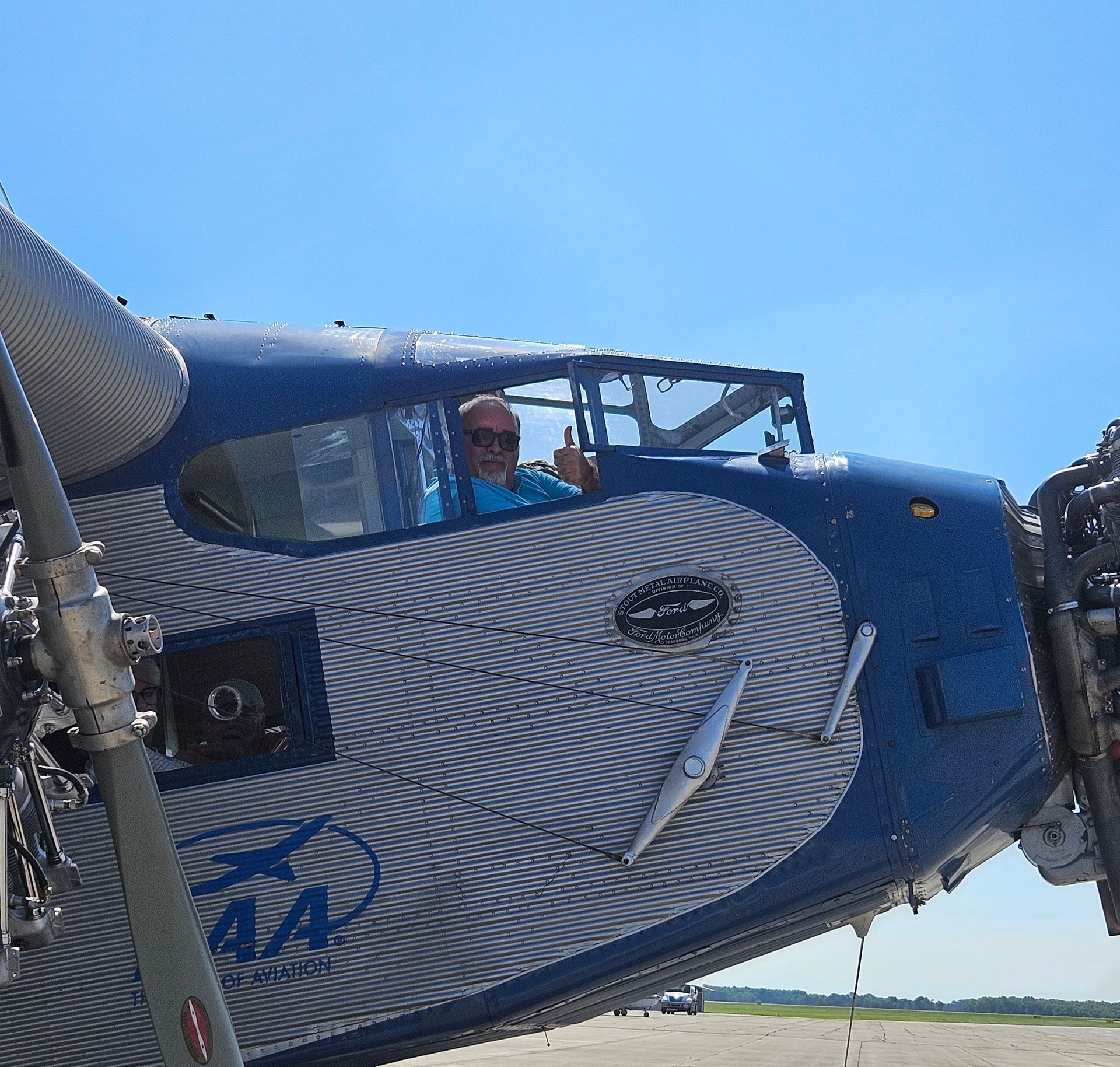 A man sits in the cockpit of an aa plane