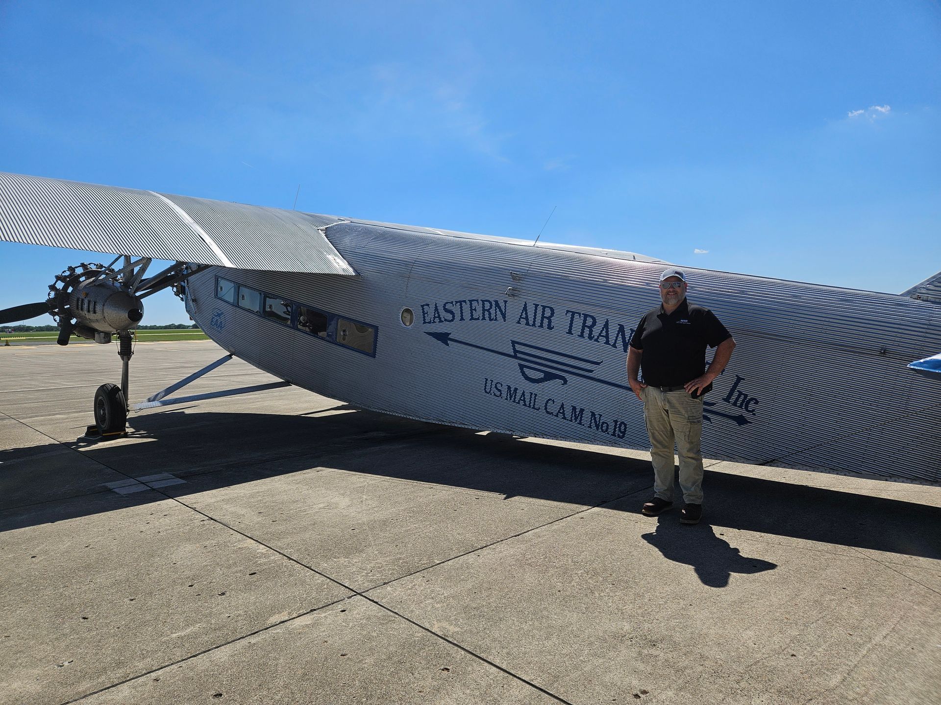 A man is standing in front of an airplane that says eastern air transport.