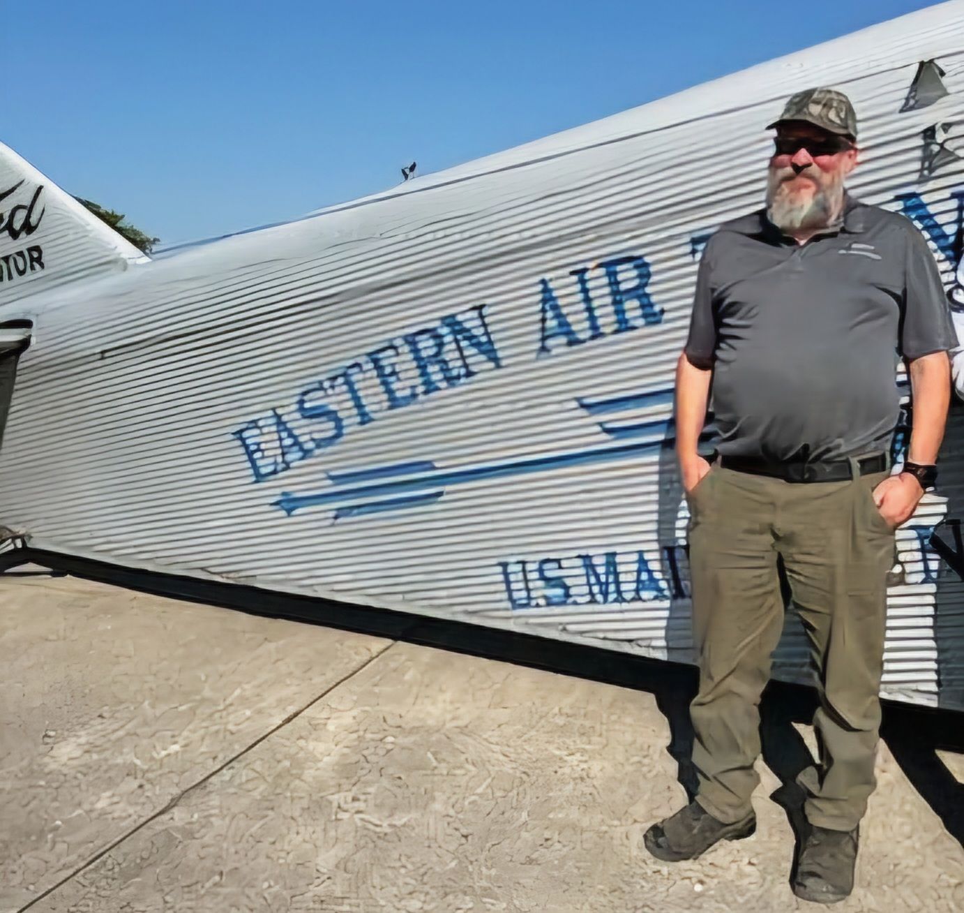 A man standing in front of a plane that says eastern air