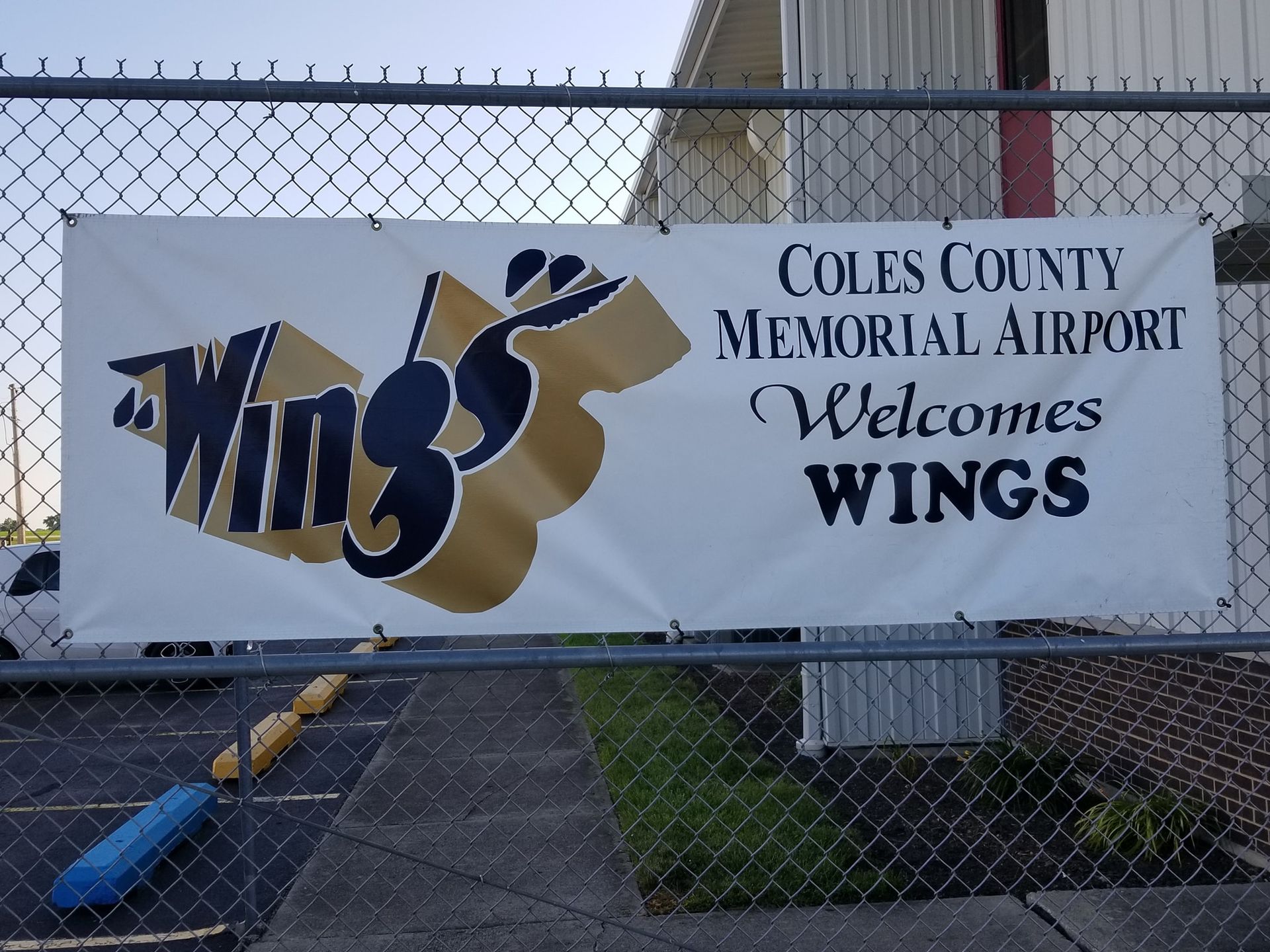 A sign for coles county memorial airport welcomes wings