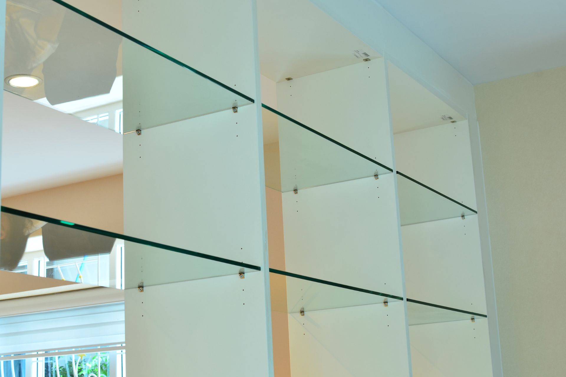 Glass shelves and white vertical supports in a bright modern interior.