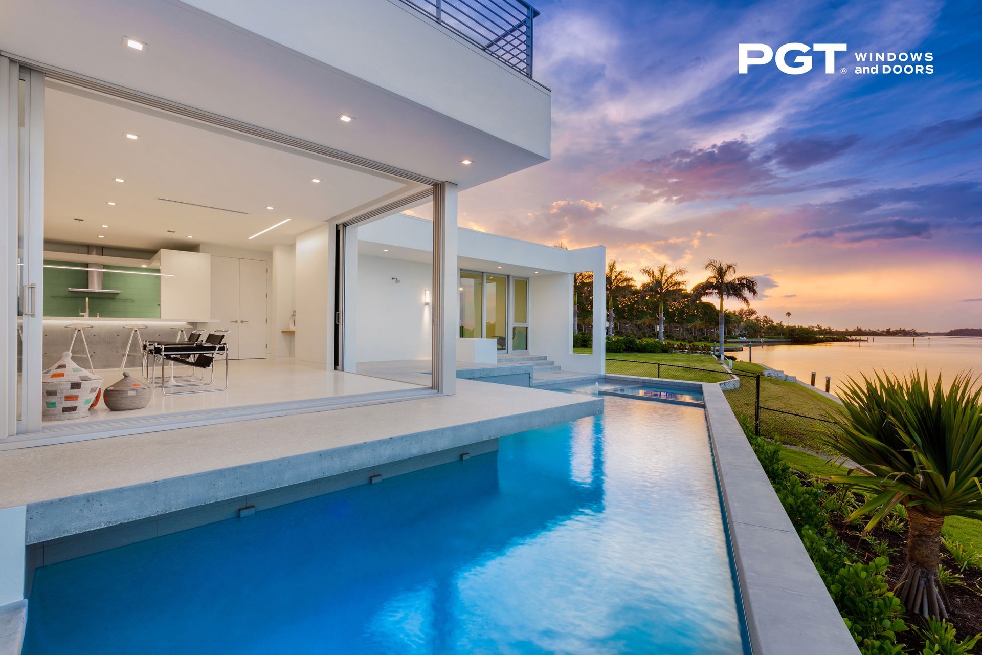 Modern villa with an infinity pool overlooking a sunset waterfront view