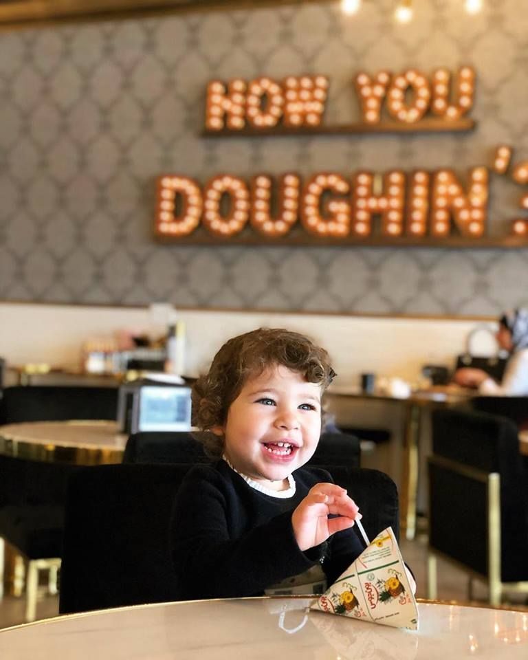Smiling child holding a treat at a cafe,