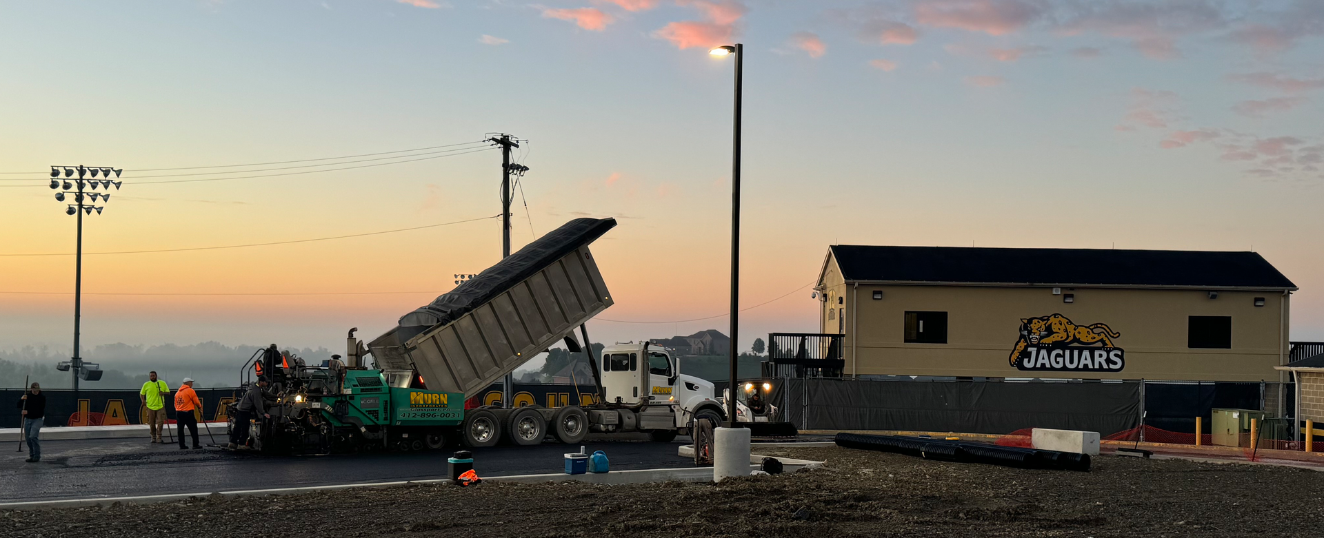 A dump truck is being loaded with concrete at a construction site.