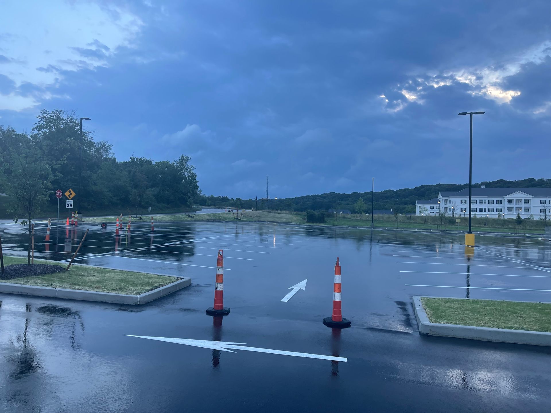 A flooded parking lot with a white building in the background.