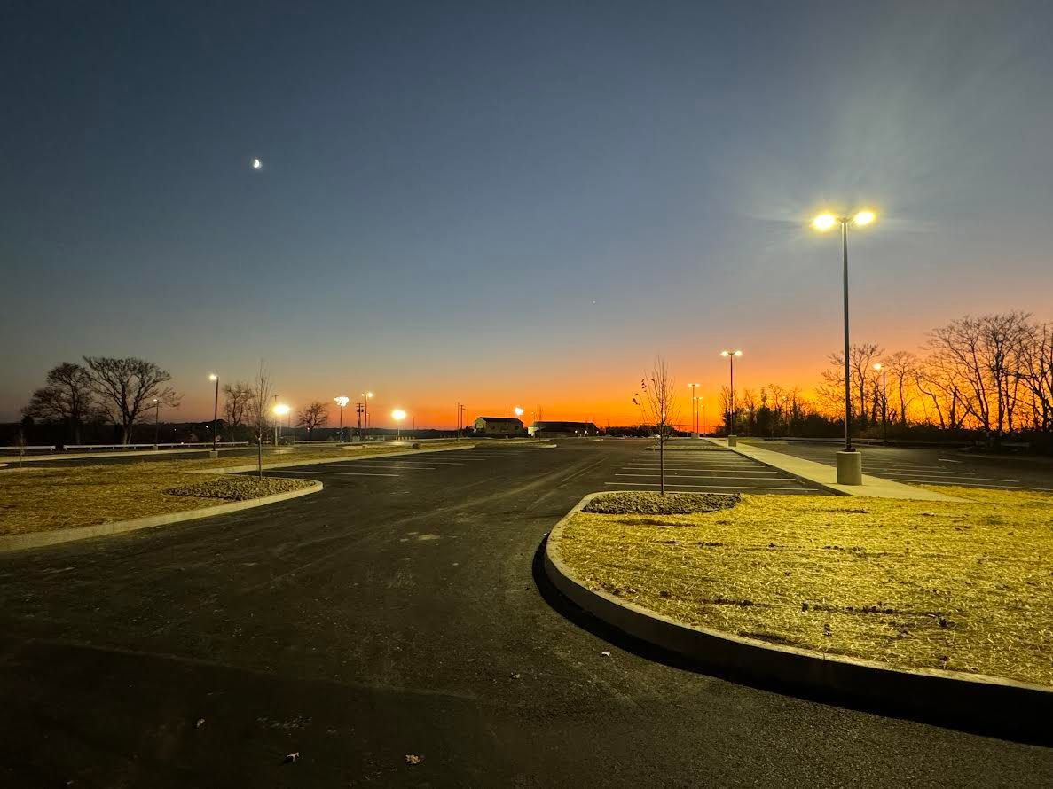 A parking lot at night with a sunset in the background.