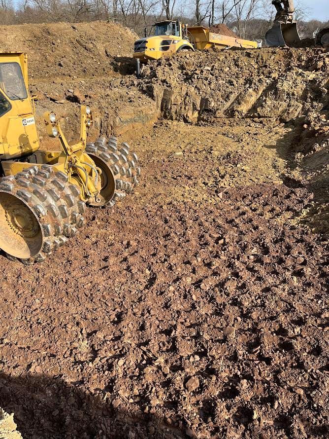 A yellow bulldozer is moving dirt on a construction site.
