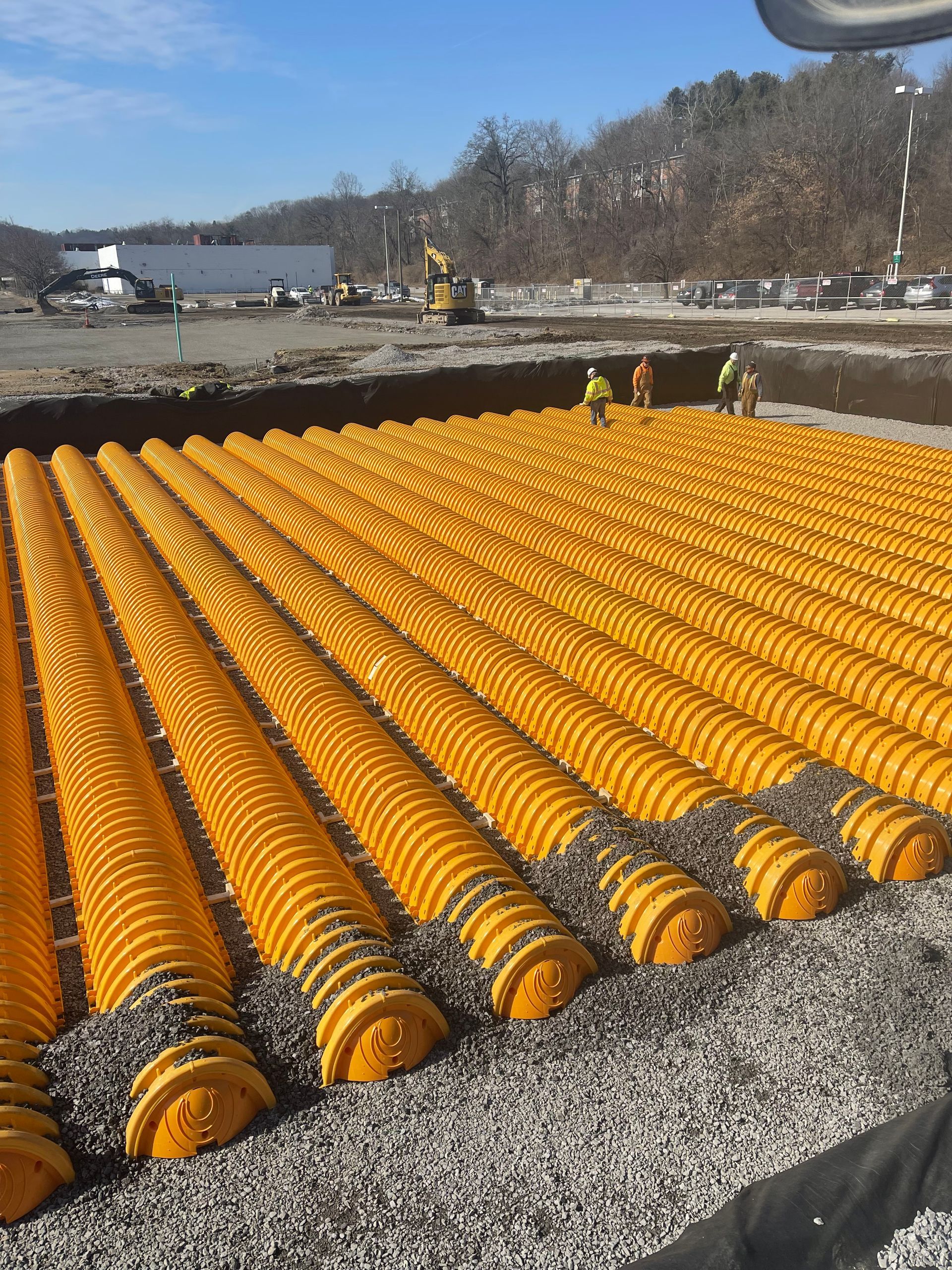 A construction site with a lot of yellow pipes and gravel