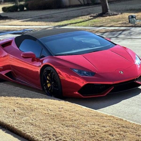 A red sports car is parked on the side of the road
