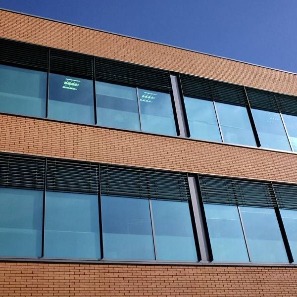 A large brick building with lots of windows and a blue sky in the background.