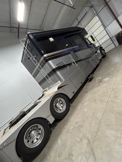A large rv is parked in a garage next to a garage door.