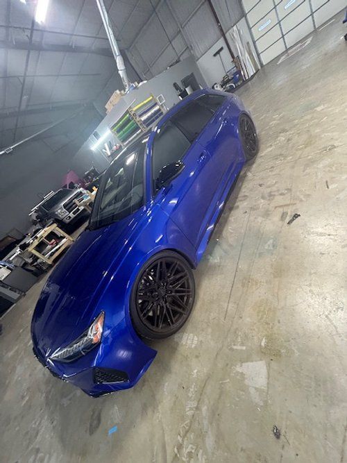 A blue car is parked in a garage.