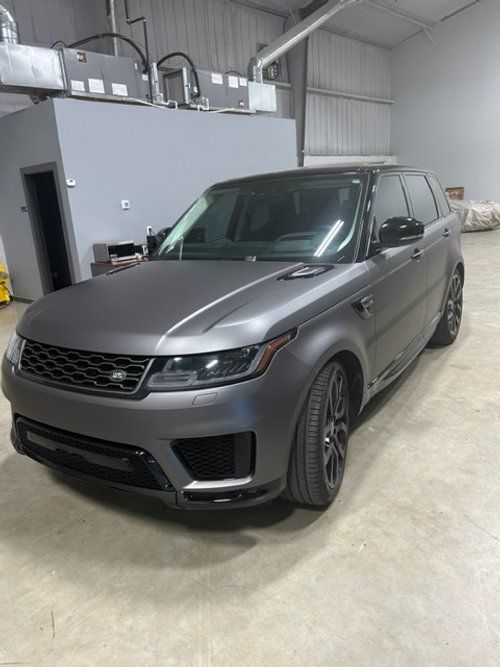 A gray range rover sport is parked in a garage.