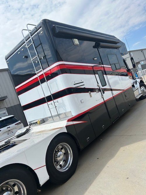 A large red and white bus is parked on the side of the road.