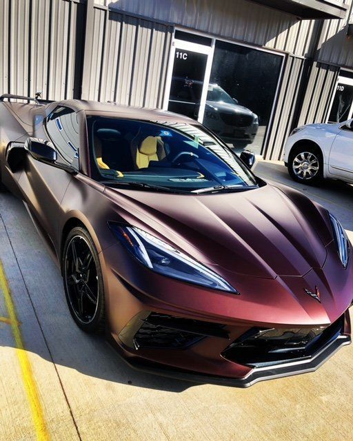 A red sports car is parked in front of a building