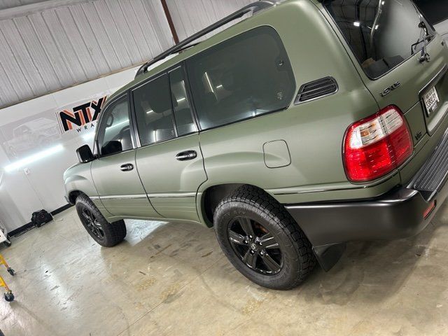 A green toyota land cruiser is parked in a garage.